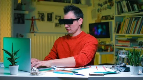 An office worker in rectangular glasses sits at a desk. 库存影片 120022515