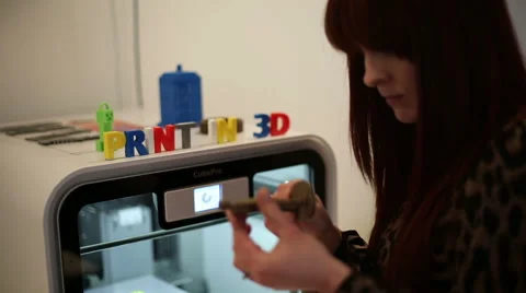 Office worker removing item from 3d printer Stock Footage 58627927