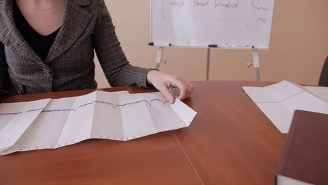 Office worker, researcher studying charts and graphs sitting at the table Stock Footage 73576243