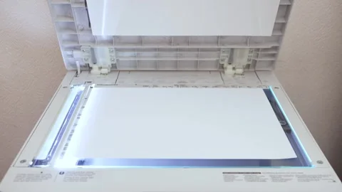 An office worker scans a sheet of A3 paper on a scanner SL Stock Footage 294976147