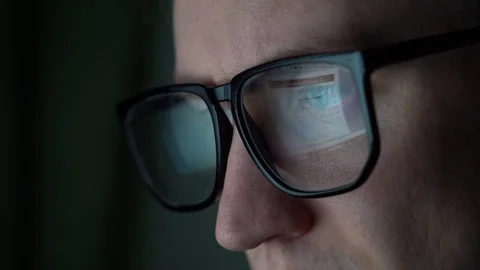An office worker sits at the computer, a monitor  is reflected in glasses Stock Footage