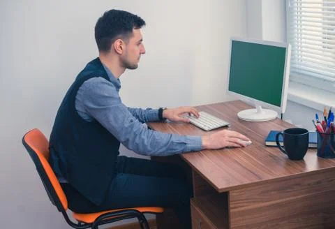 Office worker sitting at computer with Chromakey on monitor Stock Photos