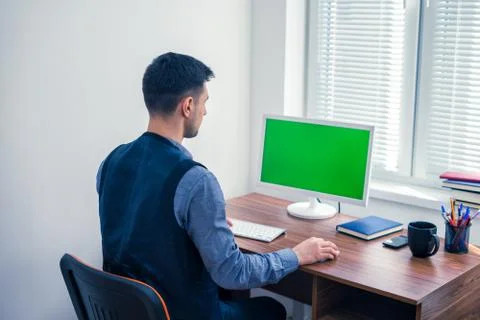 Office worker sitting at computer with Chromakey on monitor Stock Photos