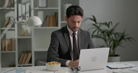 Office worker sitting at his workplace, working on laptop, typing messages. Stock-Footage 248965909