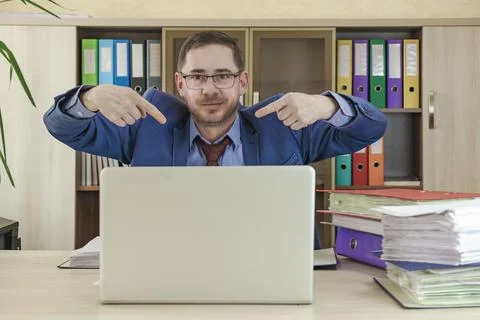 Office worker sitting at the table points the fingers Stock-Fotos