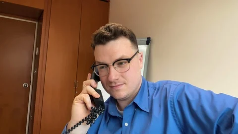 An office worker smiles while talking on the phone Stock Footage 123441069