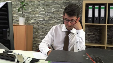 Office worker is sorting documents at the desk at the table with a computer Stock Footage 115644603