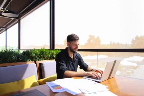Office worker sorting papers on table near laptop. Stock Photos