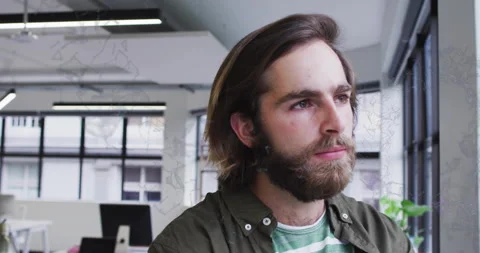 Office worker standing at window, turning head, stroking beard, analyzing data Stock Footage 314661386