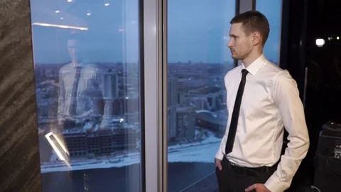 An office worker stands by the window and looks at the city Stock Footage 96014668