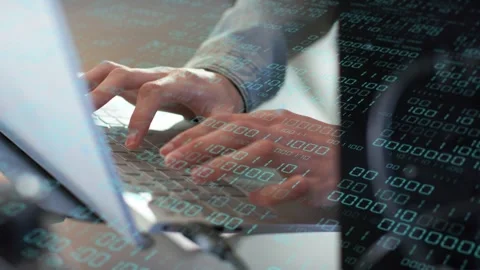 Office worker starting typing on laptop keyboard, binary overlay flowing across Stock Footage 335739559