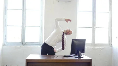 Office worker stretching behind the desk. Time to rest. Handsome young man Stock Footage 143261512