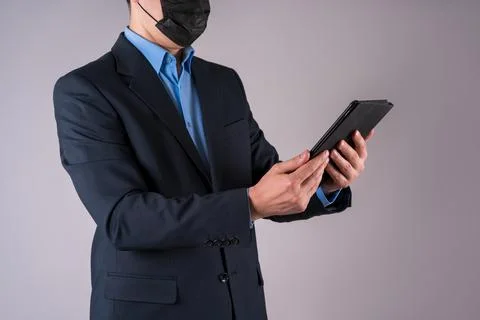 Office worker with tablet in protective mask on gray background Stock Photos