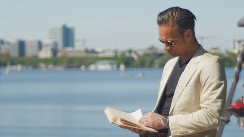 An office worker takes a break and enjoys a summer day with a book Stock Footage 89594377