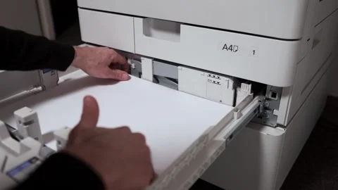 Office worker takes out a stack of paper A3 from the printer tray Stock Footage 294976227