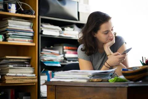 Office worker taking break to browse social media using smartphone Stock Photos