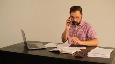 Office worker talking on the phone and looking for the necessary documents Video stock 245225259