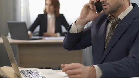 Office worker talking on smartphone with client at workplace, conversation Stock Footage 79928158