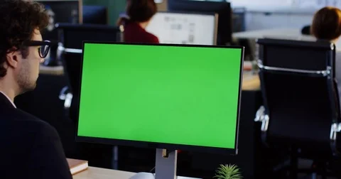 Office worker taping on the PC computer with green screen in the office space Stock Footage 82422892