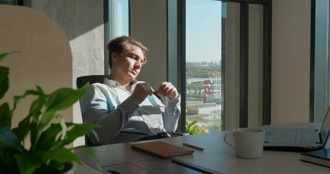 Office Worker Thinks How to Solve a Problem. He Sits At A Table And Twirls A Pen Vidéo 129065447