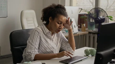 Office Worker Typing on Keyboard while Fan Working in Background Stock Footage 335461776