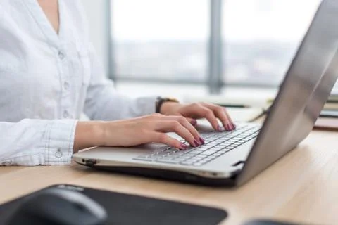 Office worker typing, working at her workplace, using laptop 写真素材