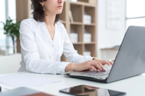 Office worker typing, working at her workplace, using laptop. Stock Photos