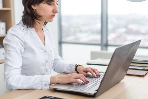 Office worker typing, working at her workplace, using laptop. Stock-Fotos