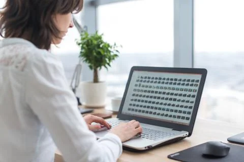 Office worker typing, working at her workplace, using laptop. Stock Photos