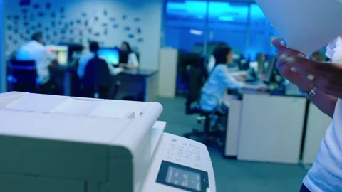 Office worker use print machine on blurred office background Stock Footage 132570657