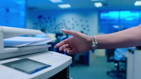 Office worker use print machine on blurred office background Stock Footage 132570732