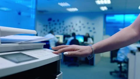Office worker use print machine on blurred office background Stock Footage 132570758