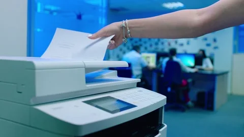 Office worker use print machine on blurred office background Stock Footage 132570762