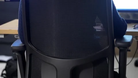 Office worker uses multiple displays to work efficiently, sitting in an Stock Footage 303258433