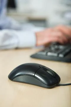 Office worker using computer, mouse in foreground Foto stock