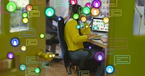 Office worker using computer responding to chat icons, leaning, typing, holding Stock Footage 321070556