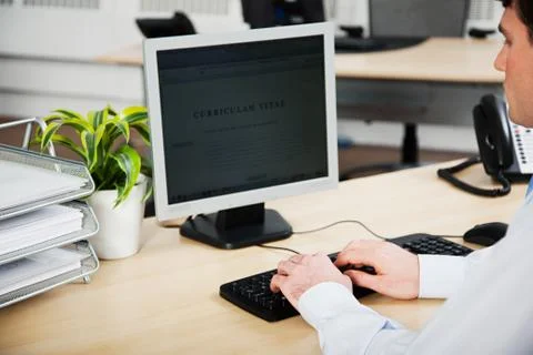 Office worker using computer to update resume Stock Photos