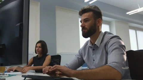 Office worker using his laptop , while his colleaugues check documents Stock Footage 68301372