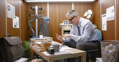Office worker using his smartphone instead of working Stock Footage 309020497