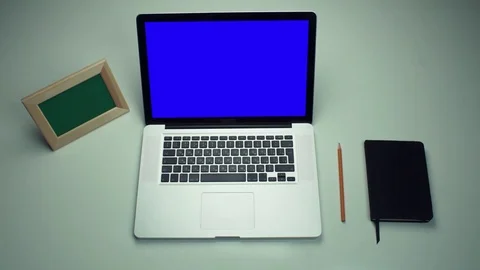 Office worker using laptop computer with green screen at white desk Stock Footage 82893606