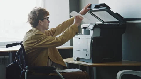 Office Worker in Wheelchair Copying Document on Printer during Workday Video stock 275071913