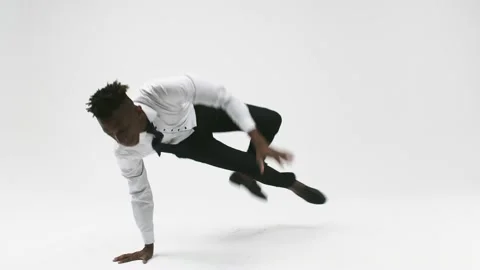 Office worker in work clothes is dancing breakdance on white background. Black Stock Footage 156950614