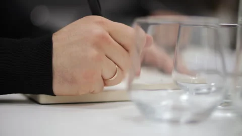 Office worker writing notes beside empty glass on desk Stock Footage 326233996