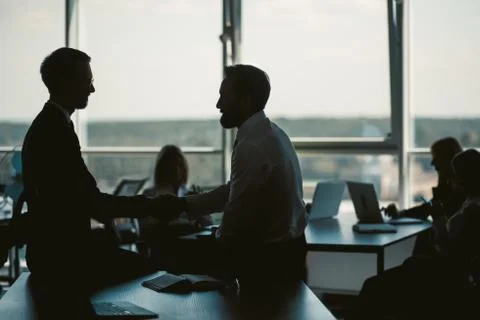 Office workers in the background of the window. Darkened image of the office Stock Photos
