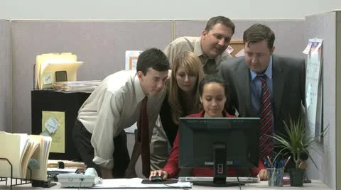 Office workers crowded around a computer watching and laughing Stock Footage 11629655