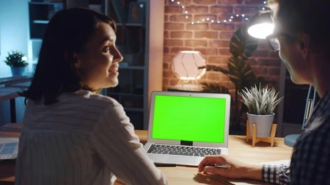 Office workers discussing business looking at green copy space laptop screen Stock Footage