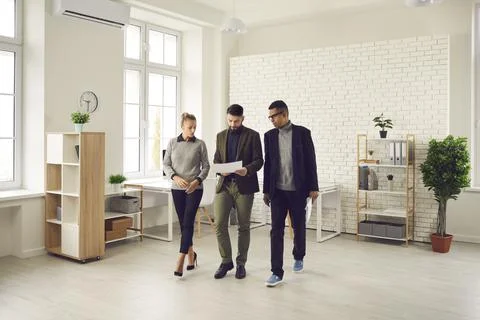 Office workers on the go review documents and discuss new business development Fotos Stock