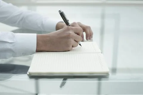 Office worker's hand writes in notebook Stock Photos