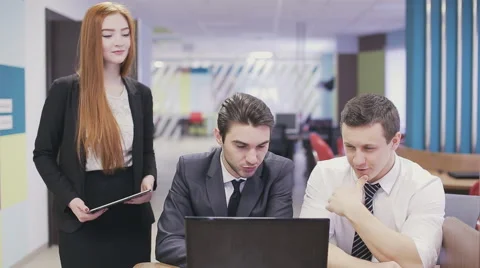 Office workers looking at laptop and discussing. Stock Footage 59852679