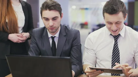 Office workers looking at laptop and discussing Stock Footage 59852743